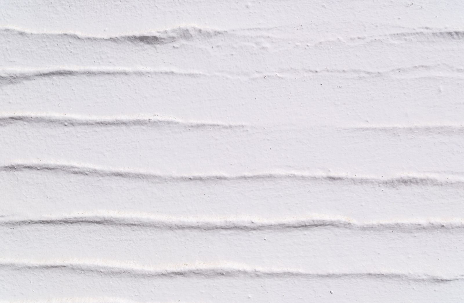 Whitewashed lime-plastered wall in strong Mediterranean sunlight