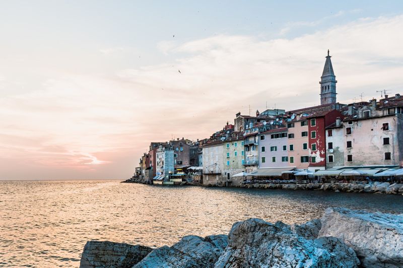 Colourful painted house facades along the waterfront of Rovinj at sunset