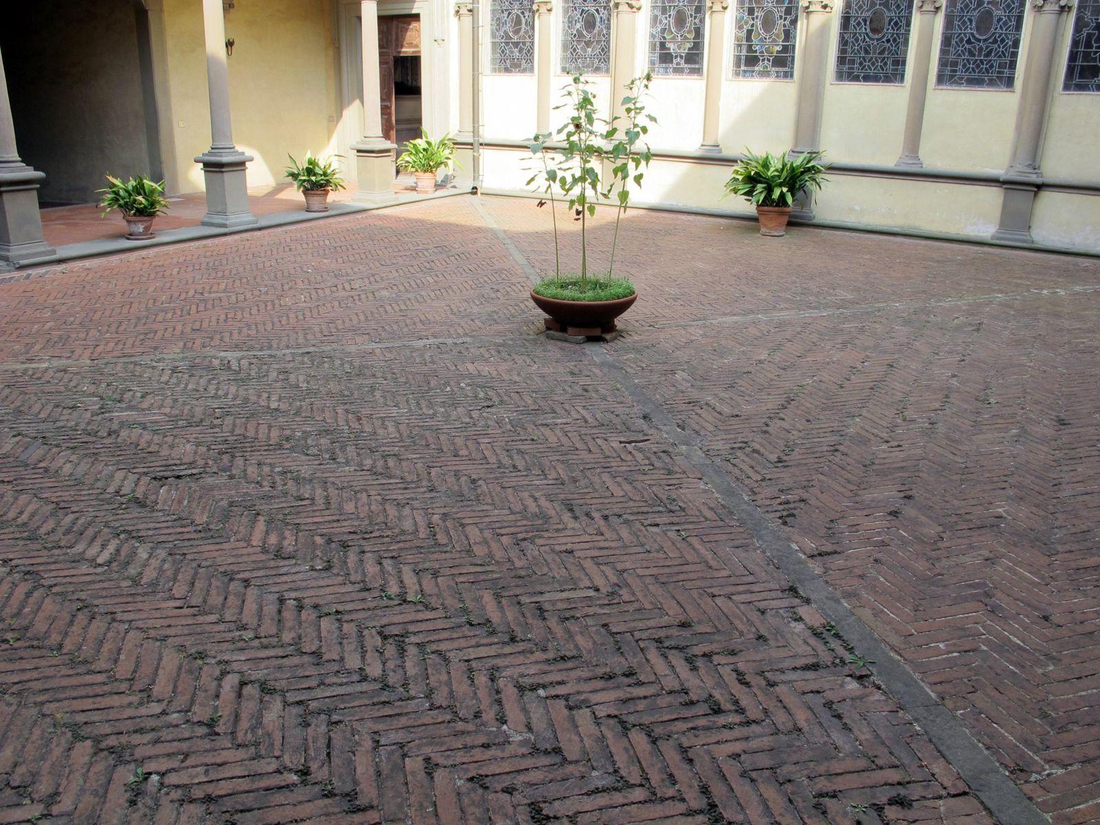 Terracotta floor tiles laid in a herringbone pattern in a cloister
