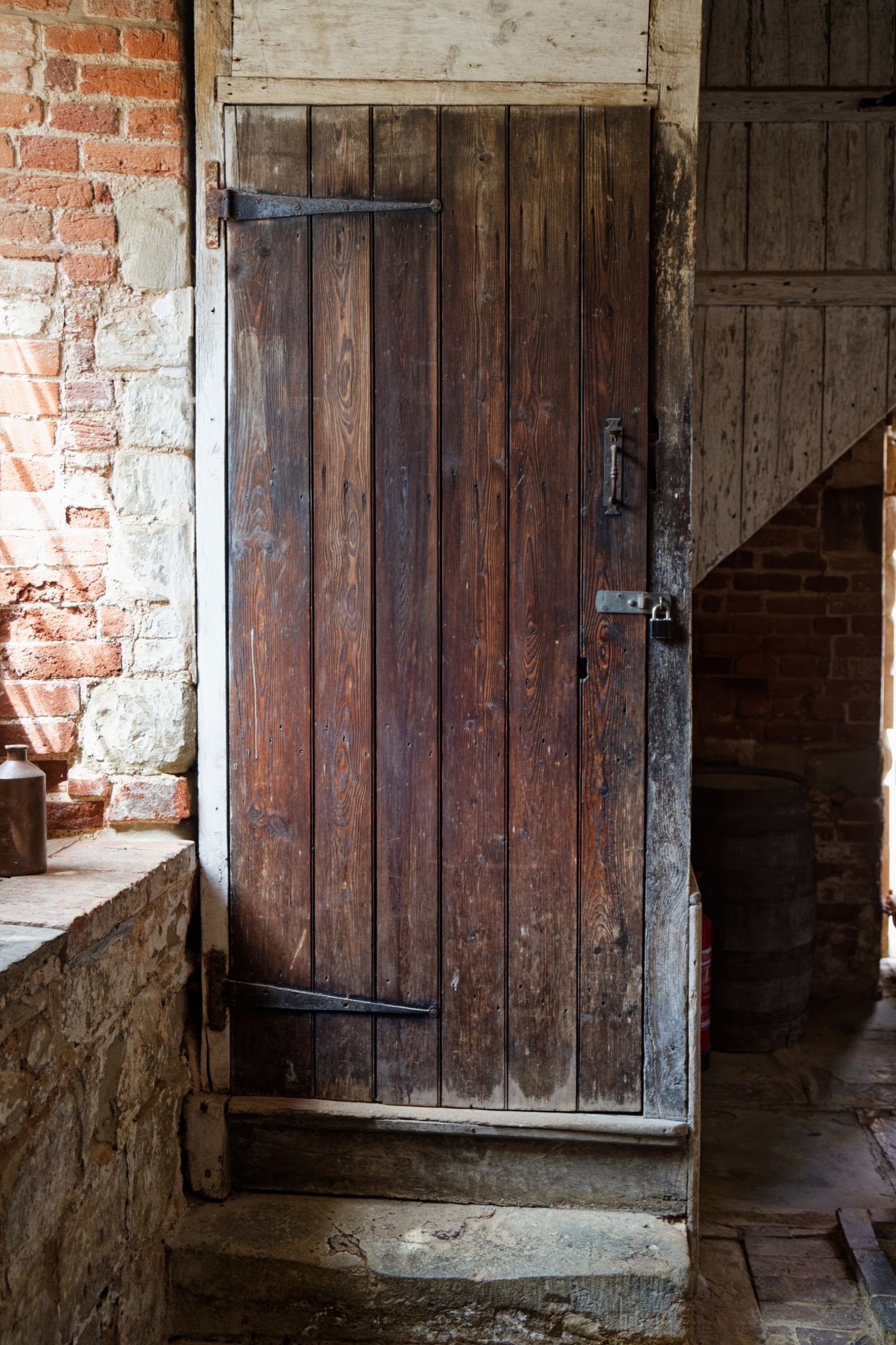 Heavy wooden plank door set in an old stone wall