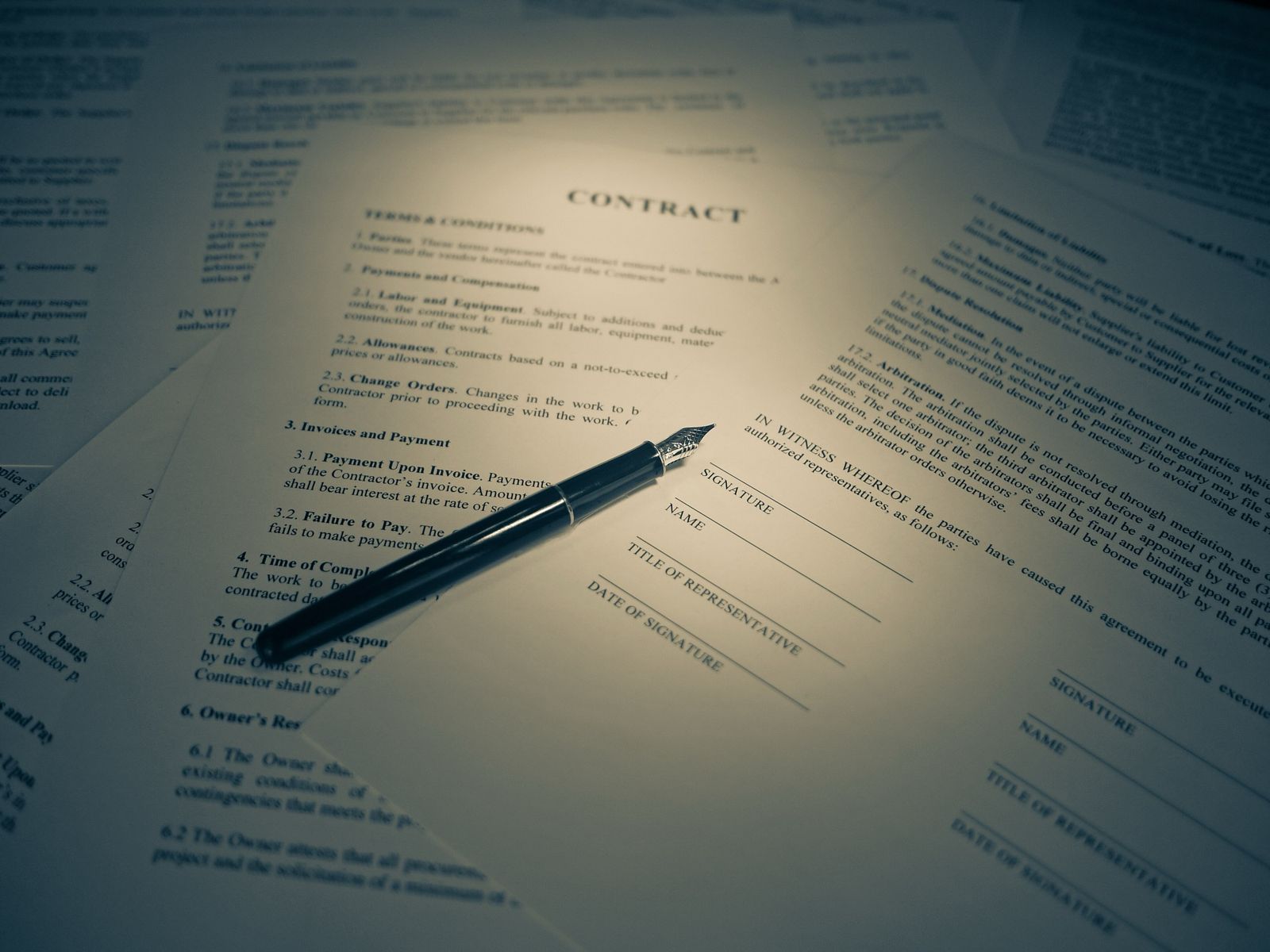 Hand signing a written agreement on a desk