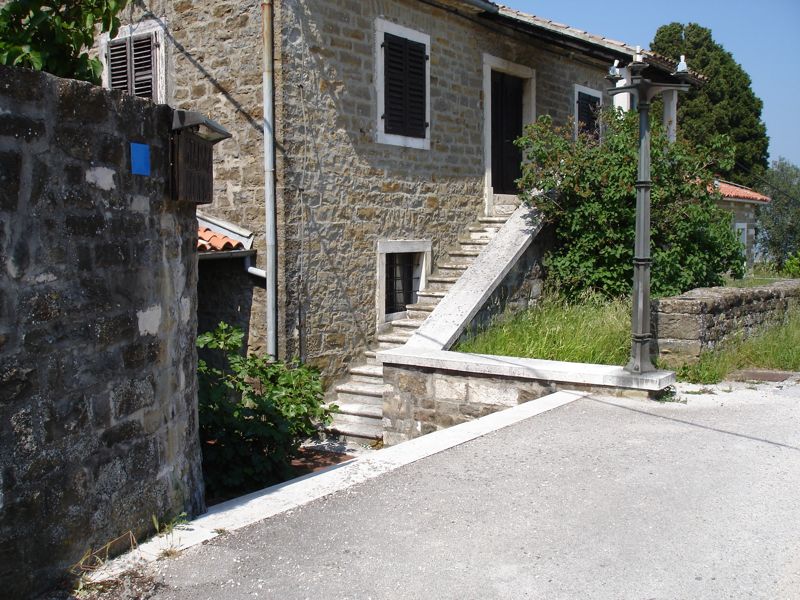 Old stone house with outside stone stairs in the village of Momjan