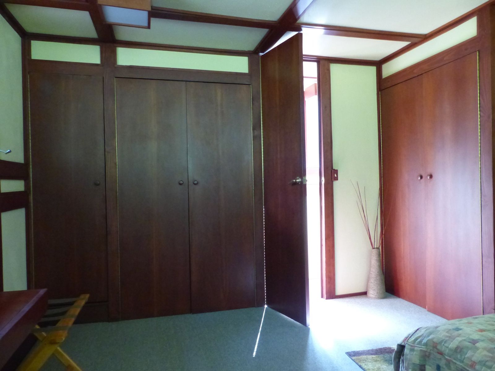 Large built-in wooden wardrobes along a bedroom wall