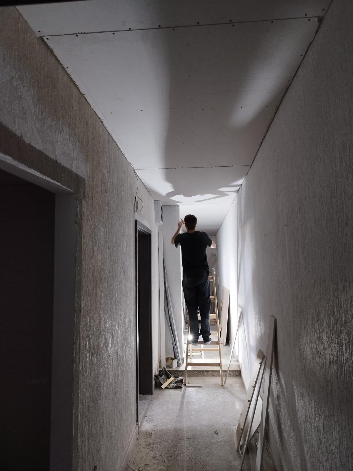 Hallway ceiling being plastered and prepared for painting